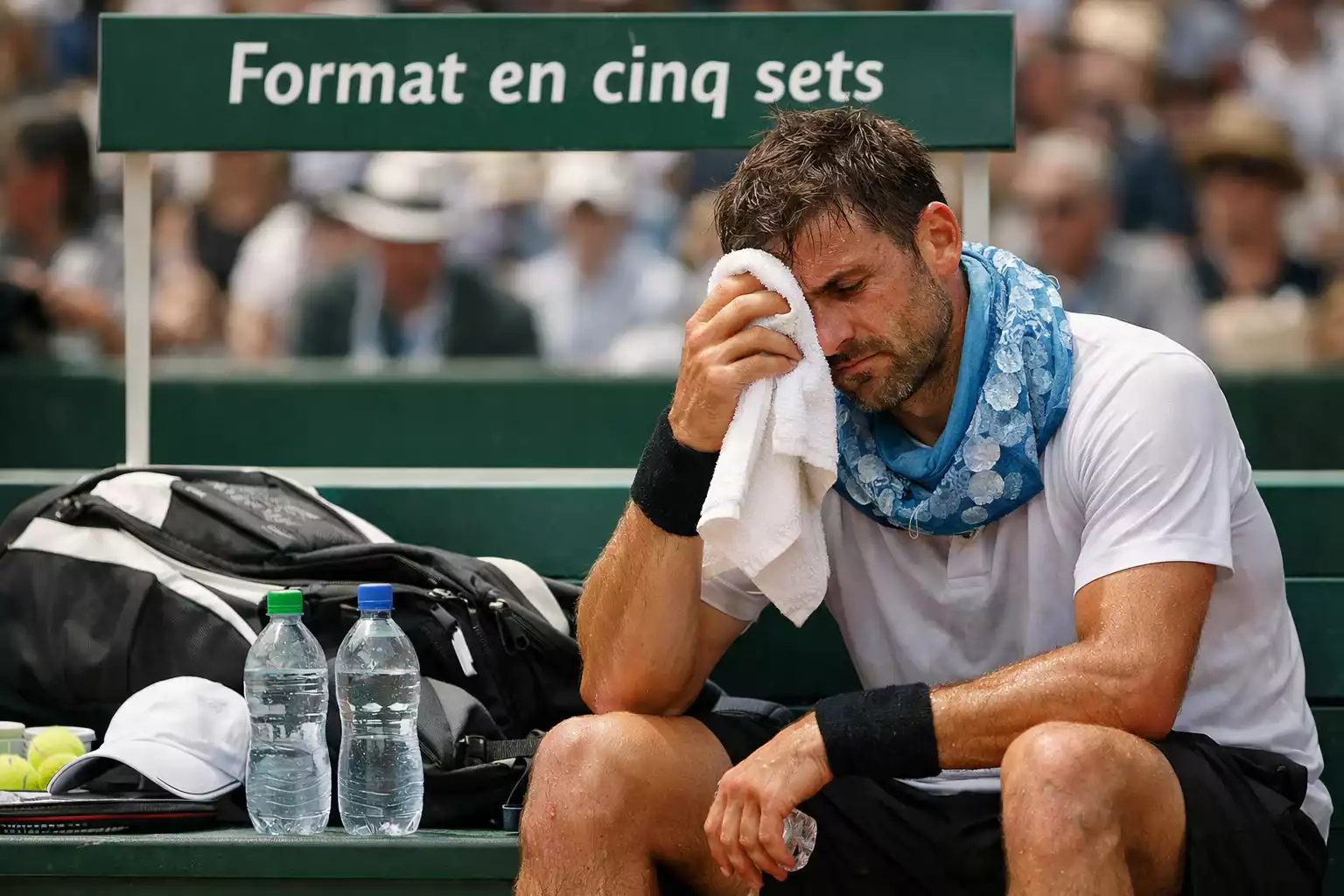 Joueur de tennis essuyant sa sueur pendant un match marathon