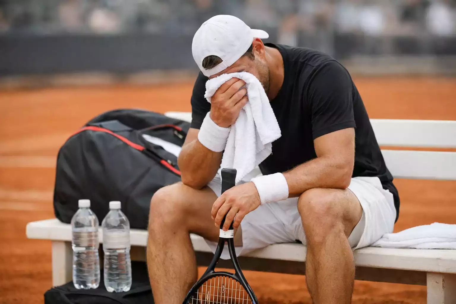 Joueur de tennis épuisé assis sur le banc pendant un changement de côté